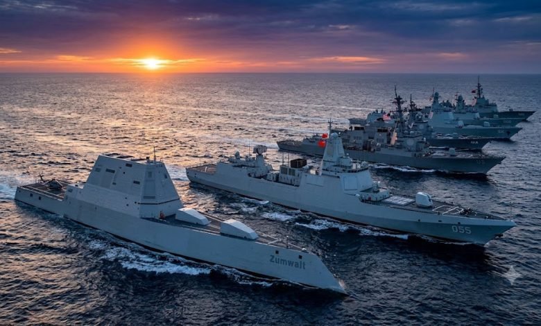 Seven powerful modern naval destroyers sailing in formation during sunset in 2026.